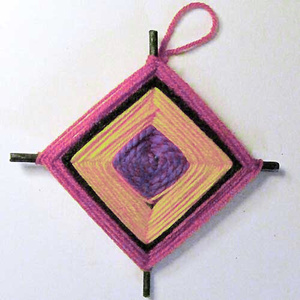 A pink, yellow, and purple woven God's Eye yarn star