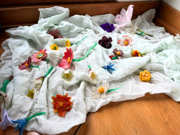Small beeswax-modelled spring flowers in pink and red with yellow centres