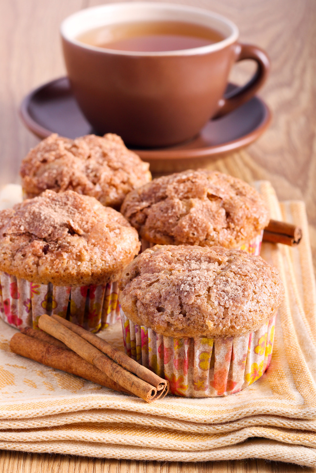 Spiced apple cakes with cinnamon in paper cases, served with a mug of tea